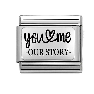 A rectangular silver charm link with a white face featuring the black text 'you & me - OUR STORY -' on a plain white background.